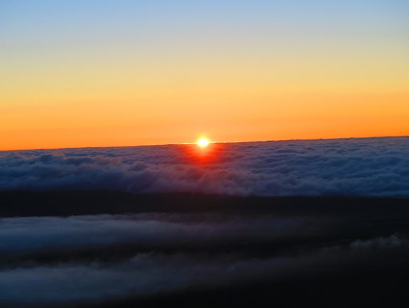 Sun setting above clouds - Mauna Kea - Big Island Hawaii