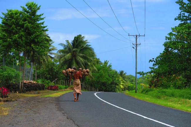 Sleepy Village Savaii Samoa - man carrying coconuts