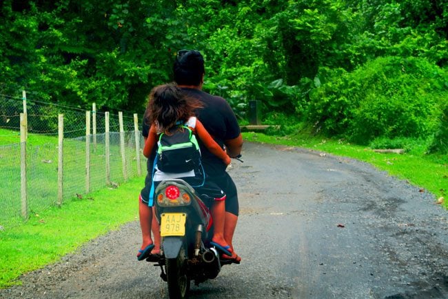 Child riding back of motorbike in Rarotonga Cook Islands