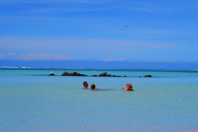 Motu beach Les Tipaniers Moorea French Polynesia people in lagoon
