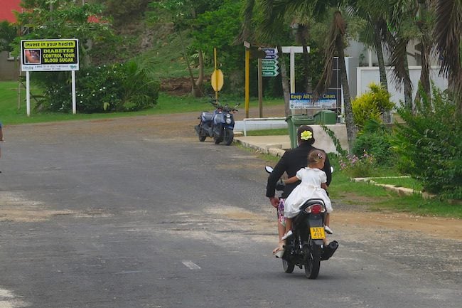 Mom and daughter scooter sunday church aitutaki