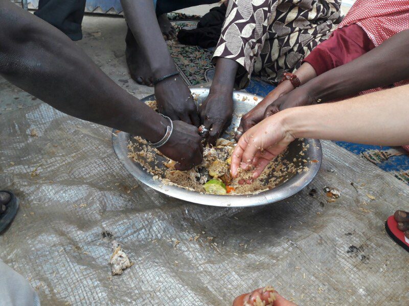 Sharing food on the street with locals in Senegal - Vagabjorn