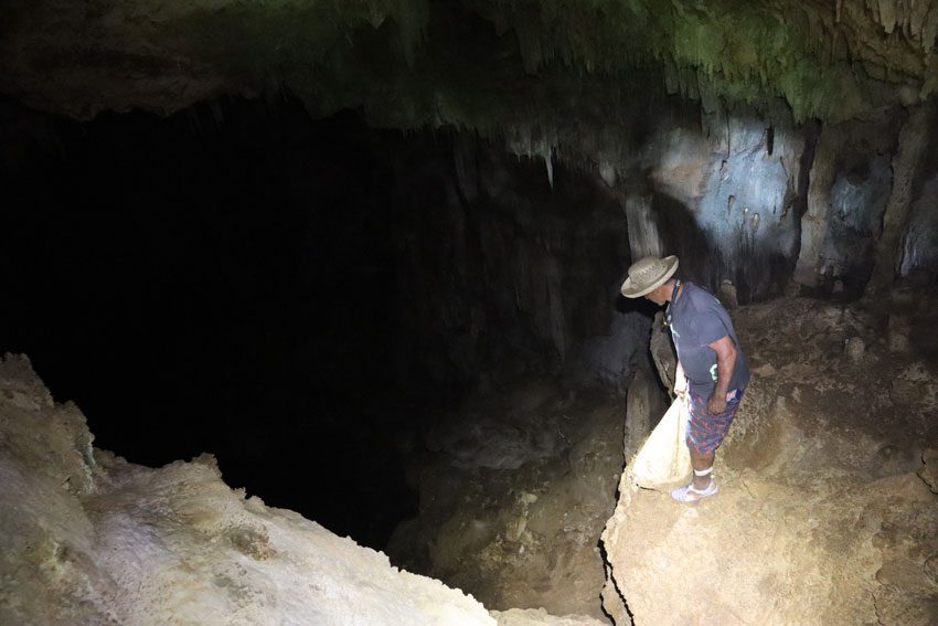 peering through secret cave - rurutu - austral islands - french polynesia