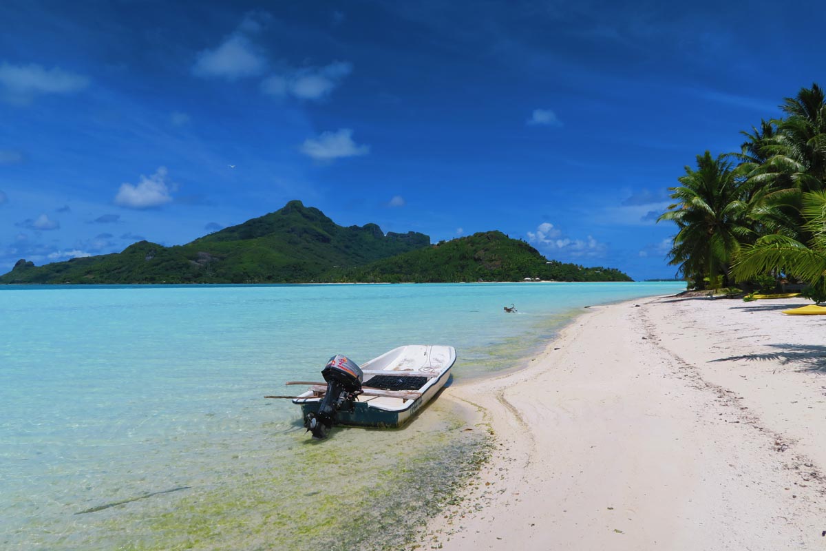 boat in Motu Auira overlooking maupiti