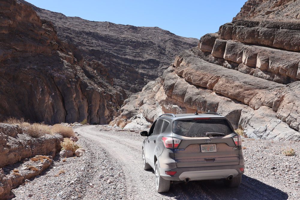 car-driving-narrow-dirt-road-in-titus-canyon-drive-death-valley