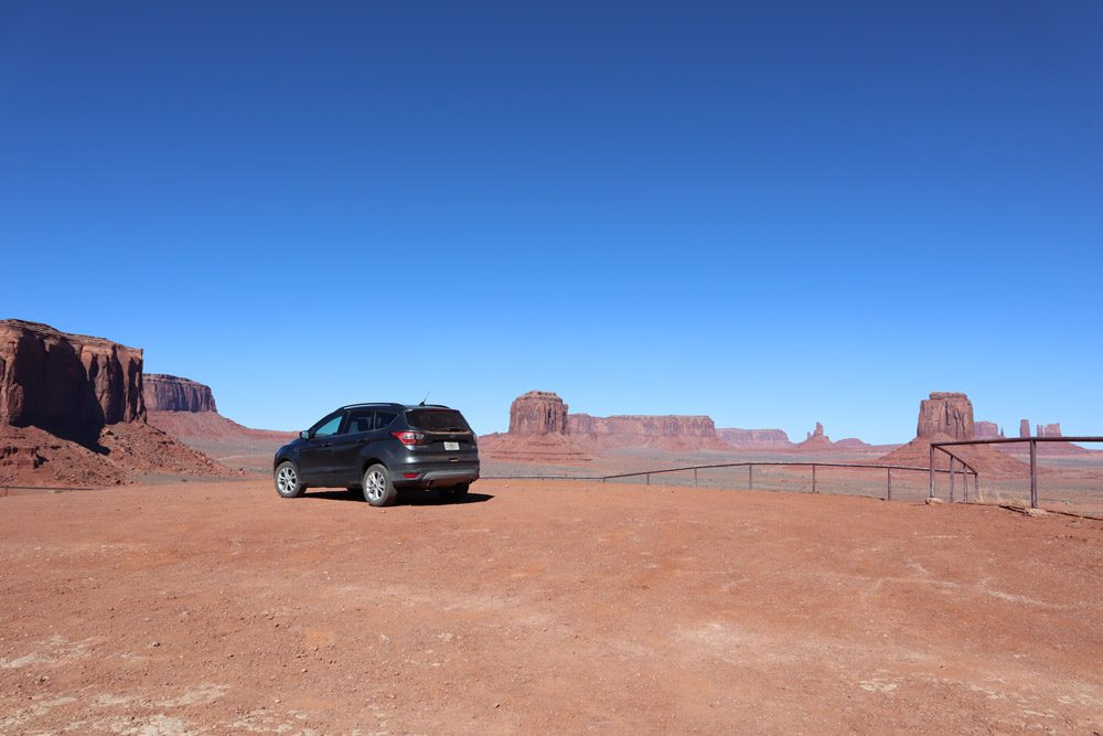 car in artists point - monument valley scenic drive