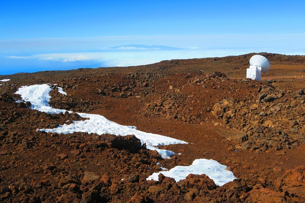 snow and antennas on mauna kea summit hawaii