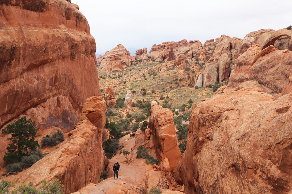 Climbing on rock face on devils garden hike - Arches NP