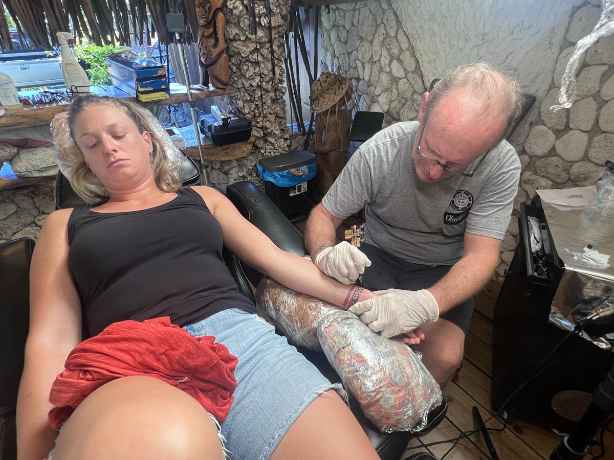 Ella getting a tattoo in Moorea