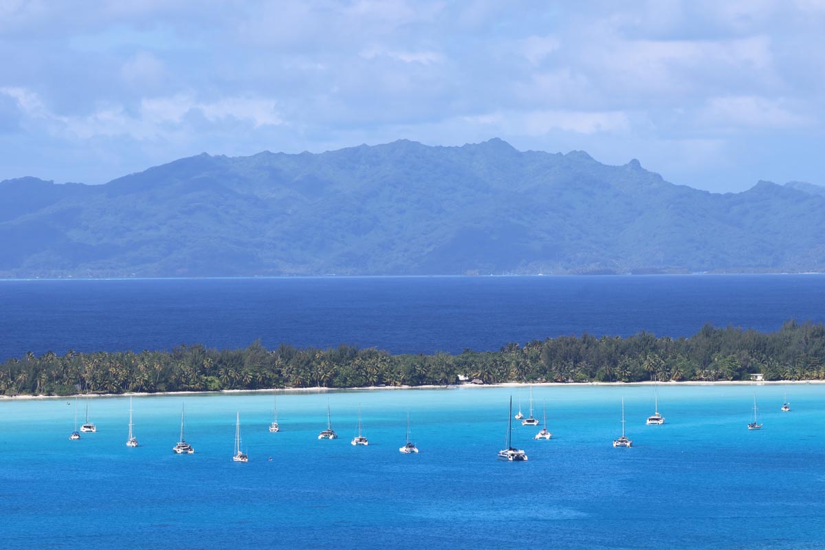 Yachts in lagoon and Tahaa - Bora Bora - circle island tour